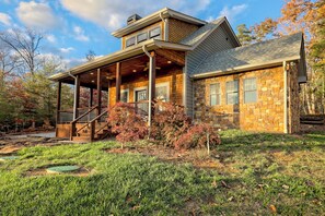 A two-story house with a covered porch and stone exterior.