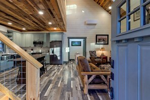 A spacious kitchen with modern appliances, a dining area with a wooden bench, and a cozy living space with a fireplace.