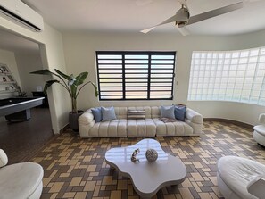 Ein Wohnzimmer mit Sofa, Couchtisch und Billardtisch.