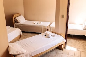 A hotel room with two single beds, a wooden headboard, and a small table. - Niv s Hotel (Monte Siao)