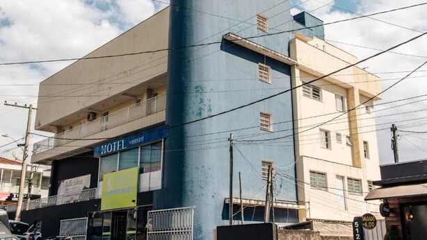 A hotel with a blue facade, a visible balcony, and a sign indicating a price of 512.