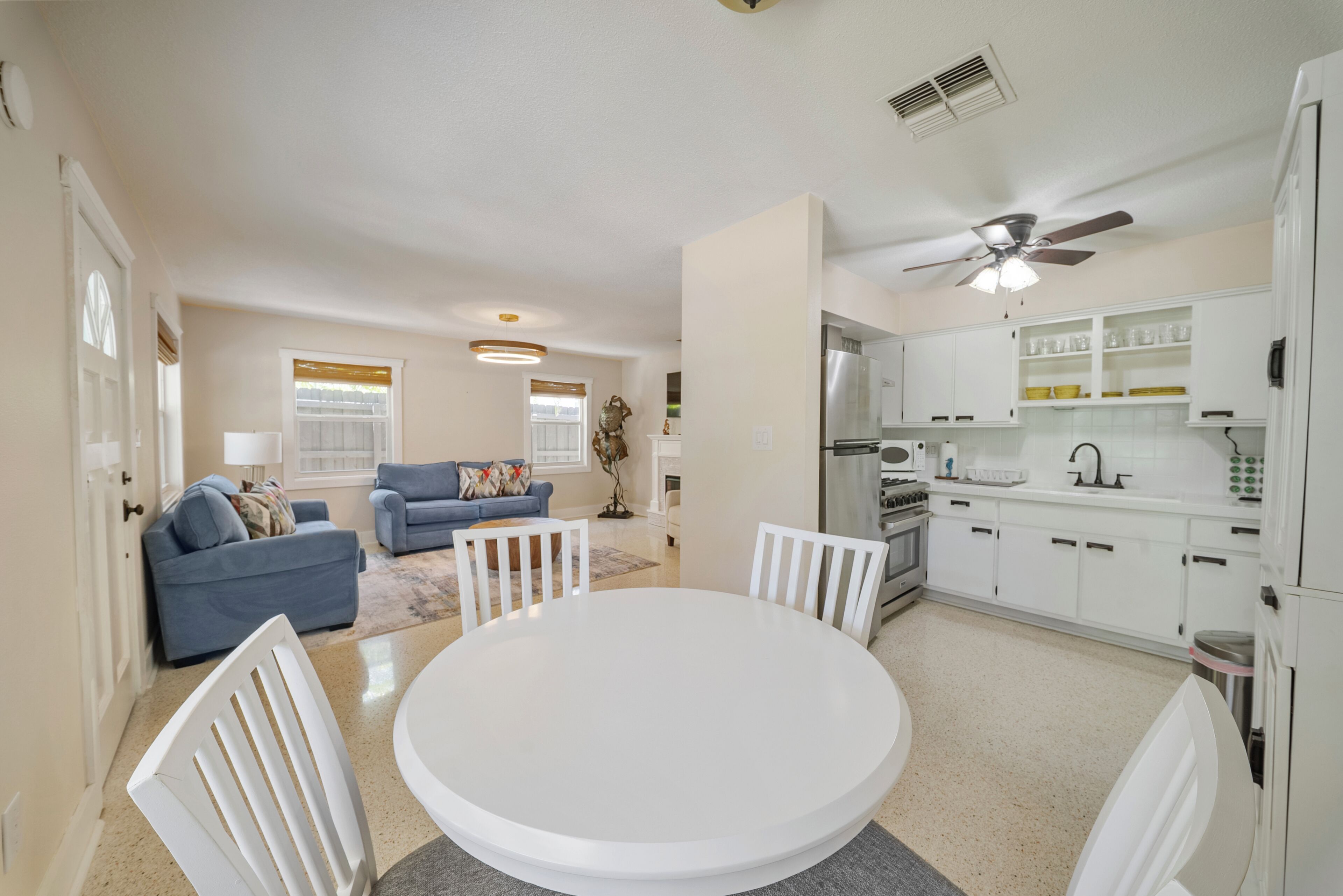 A modern kitchen with white cabinets, a stainless steel refrigerator, and a built-in oven.