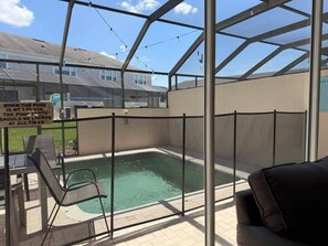 Ein Garten mit Schwimmbad, überdachter Terrasse und umzäunter Fläche.