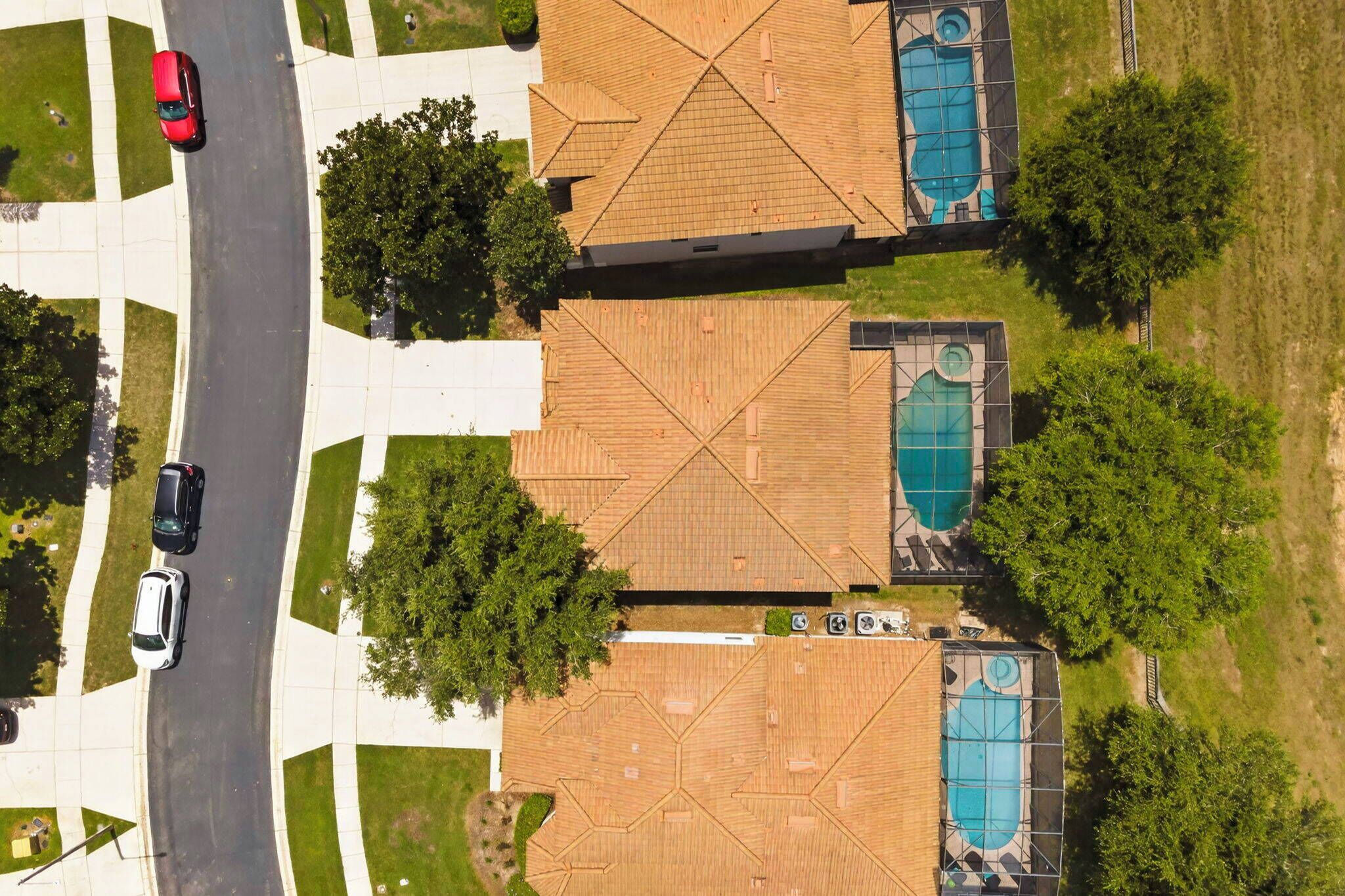 A residential area with two houses, each with a swimming pool and a garage.
