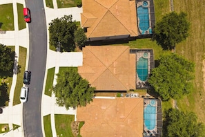 Ein Wohngebiet mit zwei Häusern, jeweils mit Swimmingpool und Garage.
