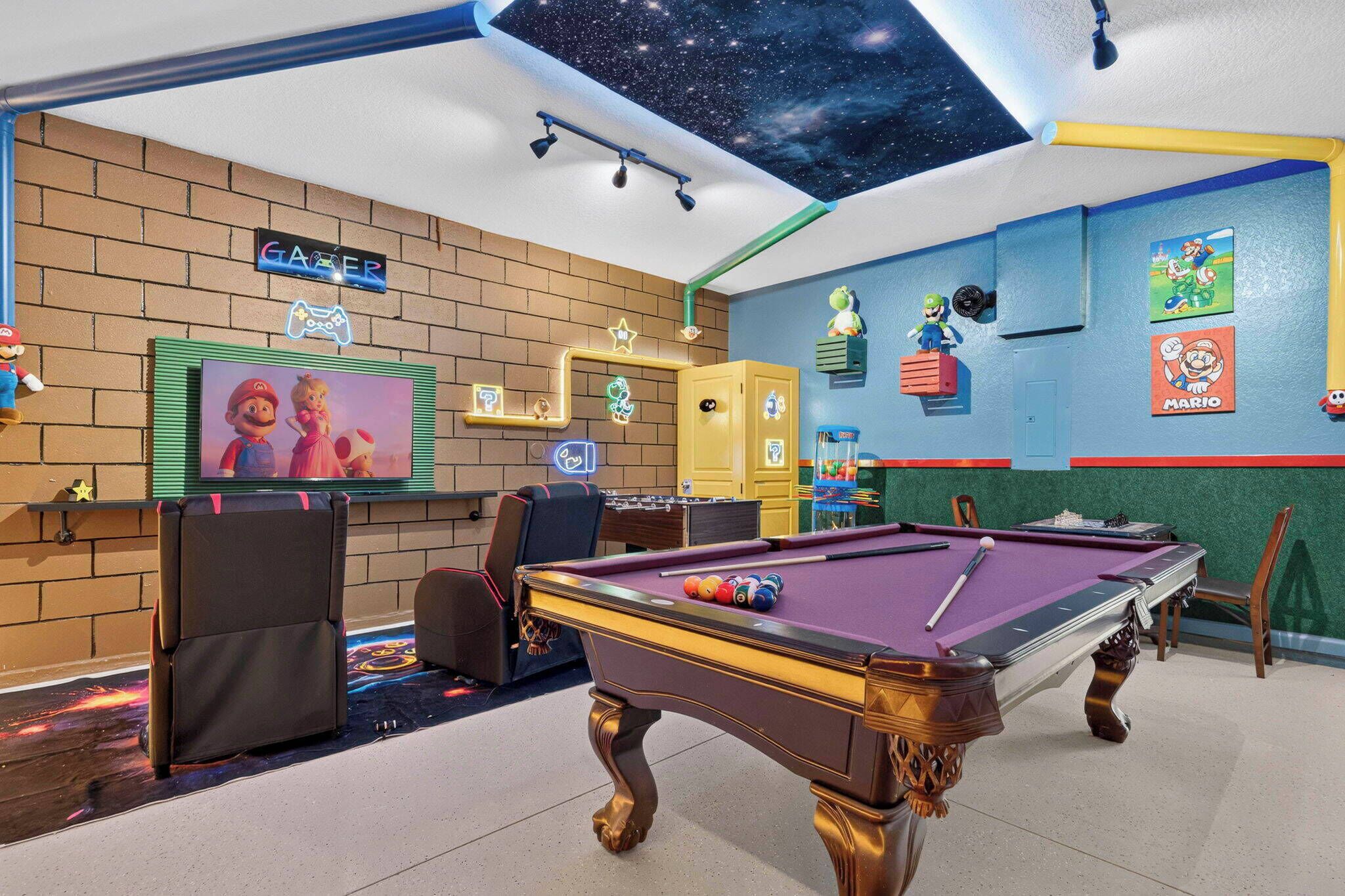A pool table with a starry ceiling, a neon sign, and Mario-themed decorations.