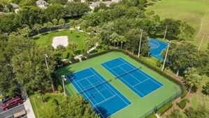 An aerial view of a tennis court complex surrounded by lush greenery and residential buildings. - Wh2596 - 6BR House at Windsor Hills Resort (Kissimmee)