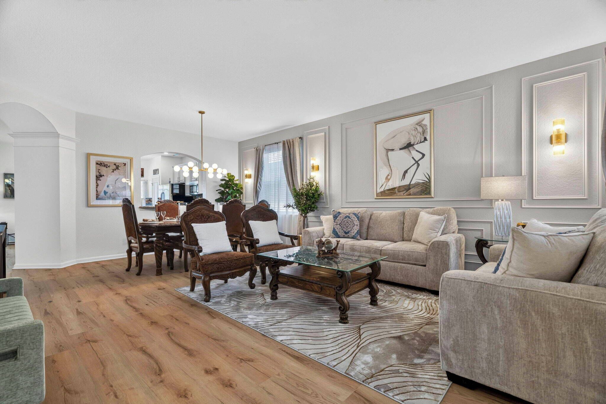 A spacious living room with a dining area, wooden flooring, and a zebra-patterned rug.