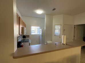 A kitchen with a countertop, stove, microwave, and cabinets. - Stunning 3 Beds Newly Townhouse (Kissimmee)