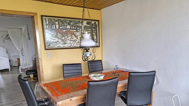 A dining area with a wooden table, black chairs, and a patterned table runner. - 6 Person Holiday Home in Nykobing M (Nykobing Mors)