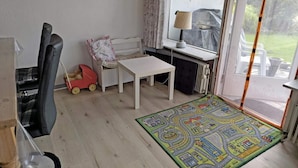 A room with a white table, a child's toy, a radiator, and a view through a glass door. - 6 Person Holiday Home in Nykobing M (Nykobing Mors)