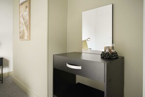 A modern, minimalist bedside table with a mirror, a drawer, and a decorative item on top. - Horden 2BR Home Sleeps 6 By Stay With us (Peterlee)