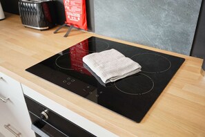 A kitchen with a black induction cooktop and a stainless steel range hood. - Horden 2BR Home Sleeps 6 By Stay With us (Peterlee)