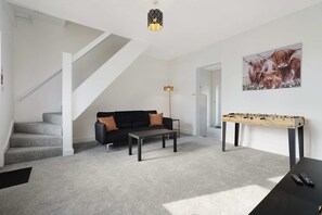 A modern living room with a sofa, coffee table, and a foosball table. - Horden 2BR Home Sleeps 6 By Stay With us (Peterlee)