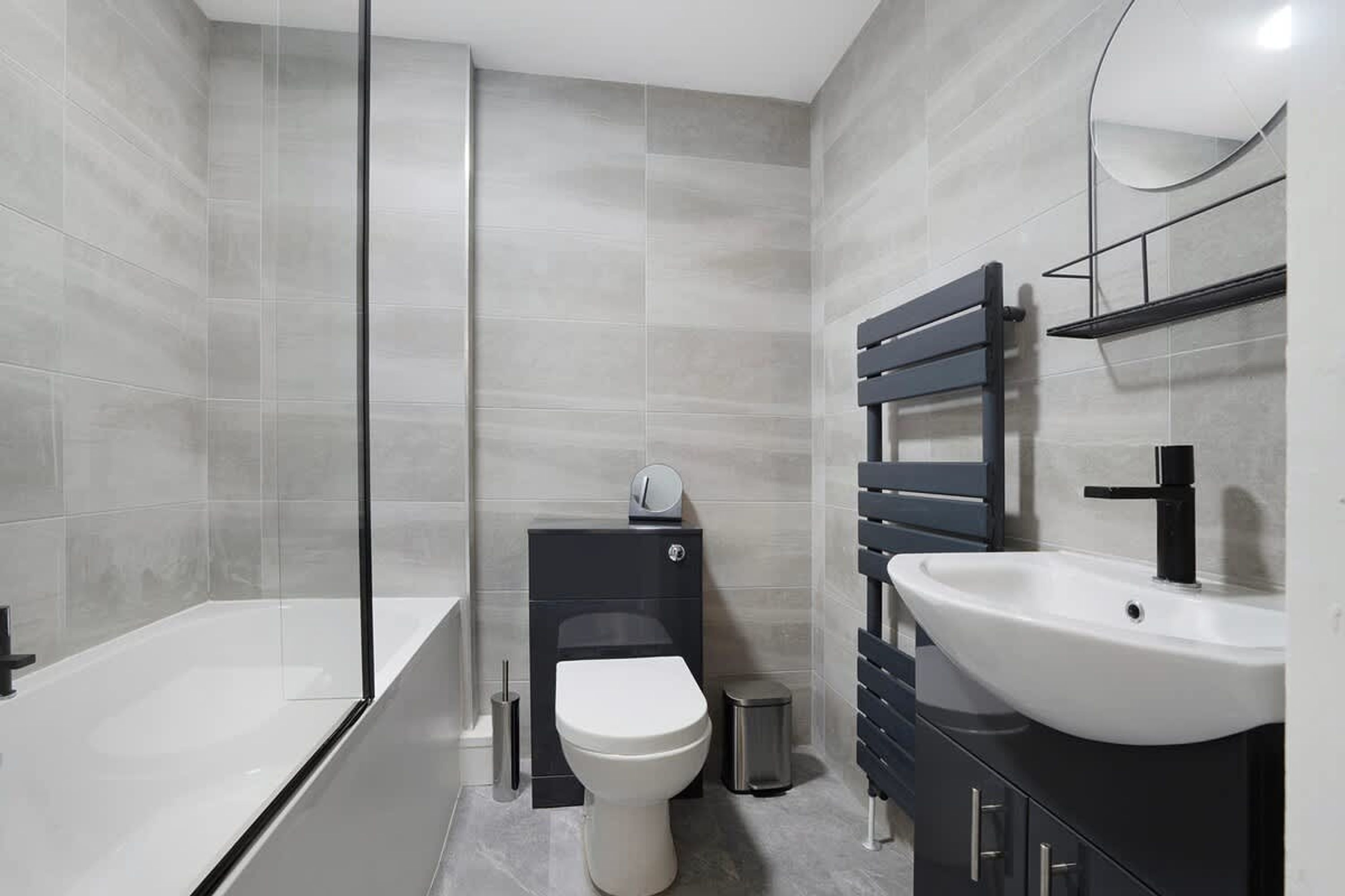 Un bagno moderno con vasca, water e lavabo.
