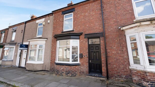 A row of terraced houses with a ground floor shop on the left. - 2BR Darlington Home by Stay With Us (Darlington)
