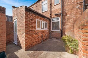 A brick house with a small garden, a door, and a window. - 2BR Darlington Home by Stay With Us (Darlington)