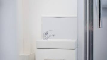 A bathroom with a white sink, a mirror, and a door.