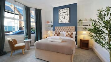 Une chambre d’hôtel avec un grand lit, une chaise, une petite table, une lampe de chevet et une vue sur la rue.