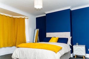 Ein Schlafzimmer mit einem Bett, einem Nachttisch und einem Fenster mit Vorhängen.
