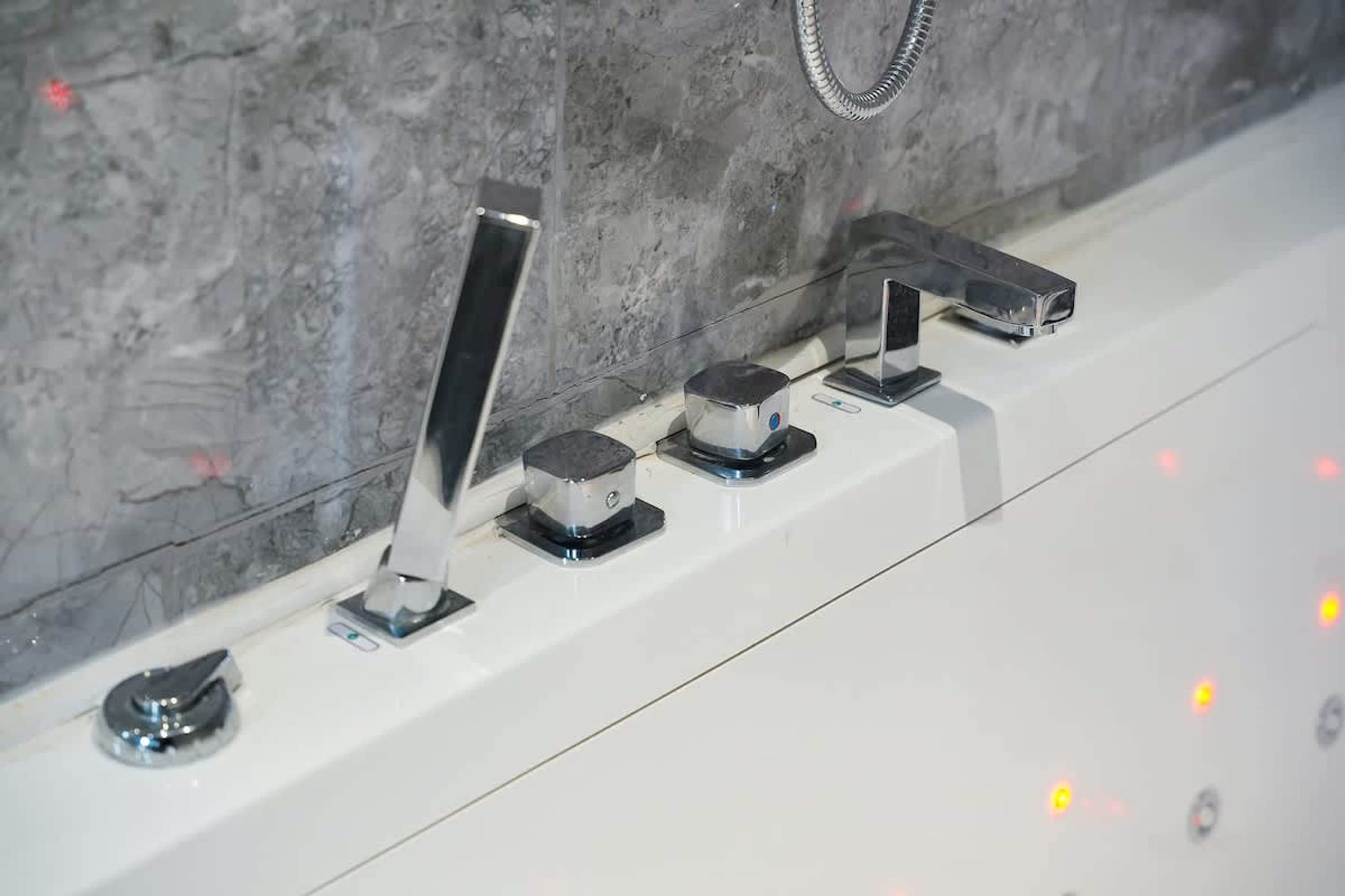 A bathroom with a white sink, a chrome faucet, and a towel rack.
