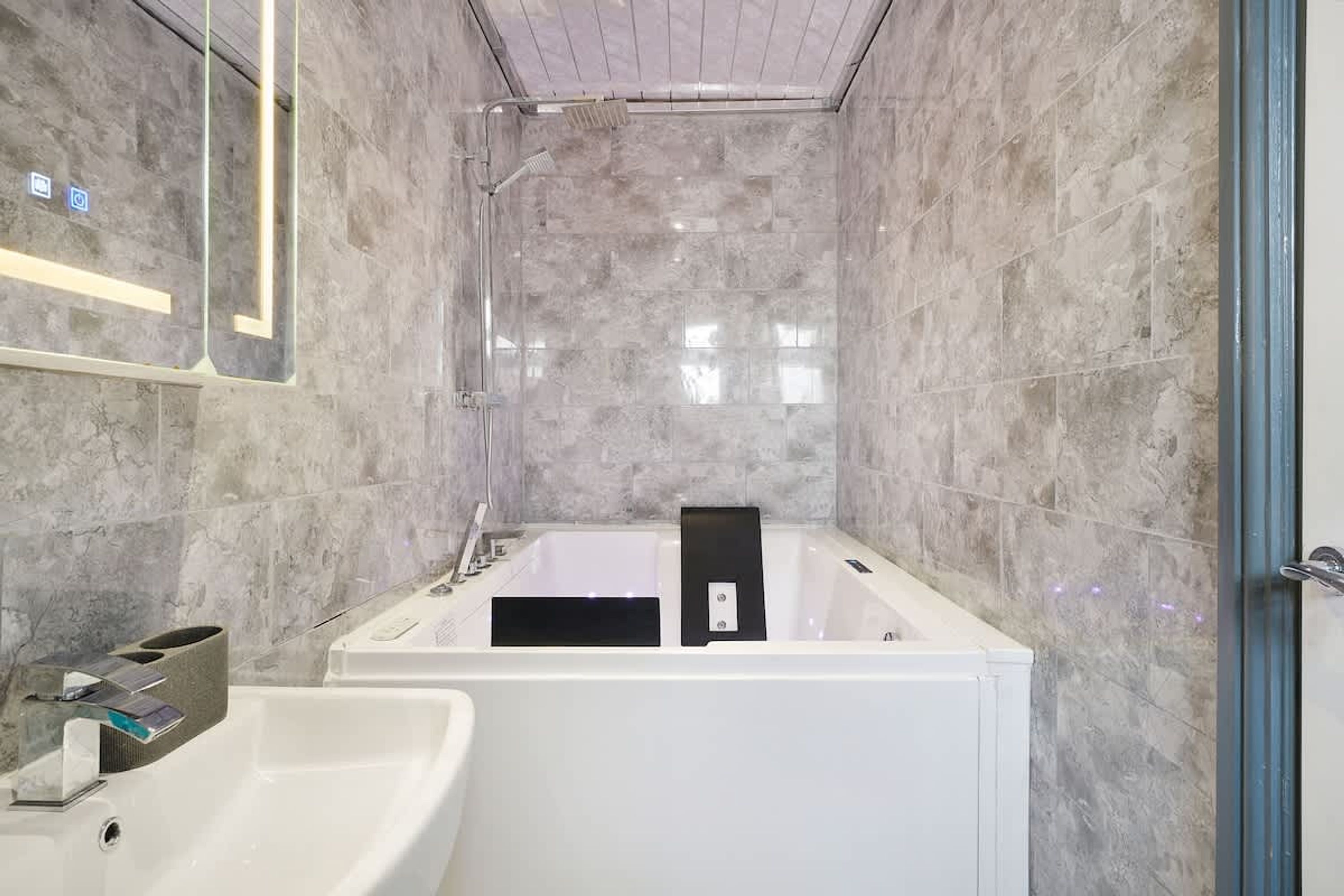 A modern bathroom with a freestanding bathtub, a sink, and a mirror.