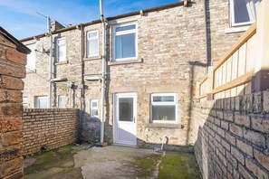 A narrow alleyway between terraced houses with a brick wall on one side and a wooden fence on the other. - Relaxing 2BR in Billy Row Wifi by Stay With Us (Crook)