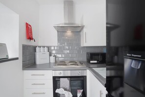 Eine moderne Küche mit eingebautem Ofen, Mikrowelle und Wasserspender.