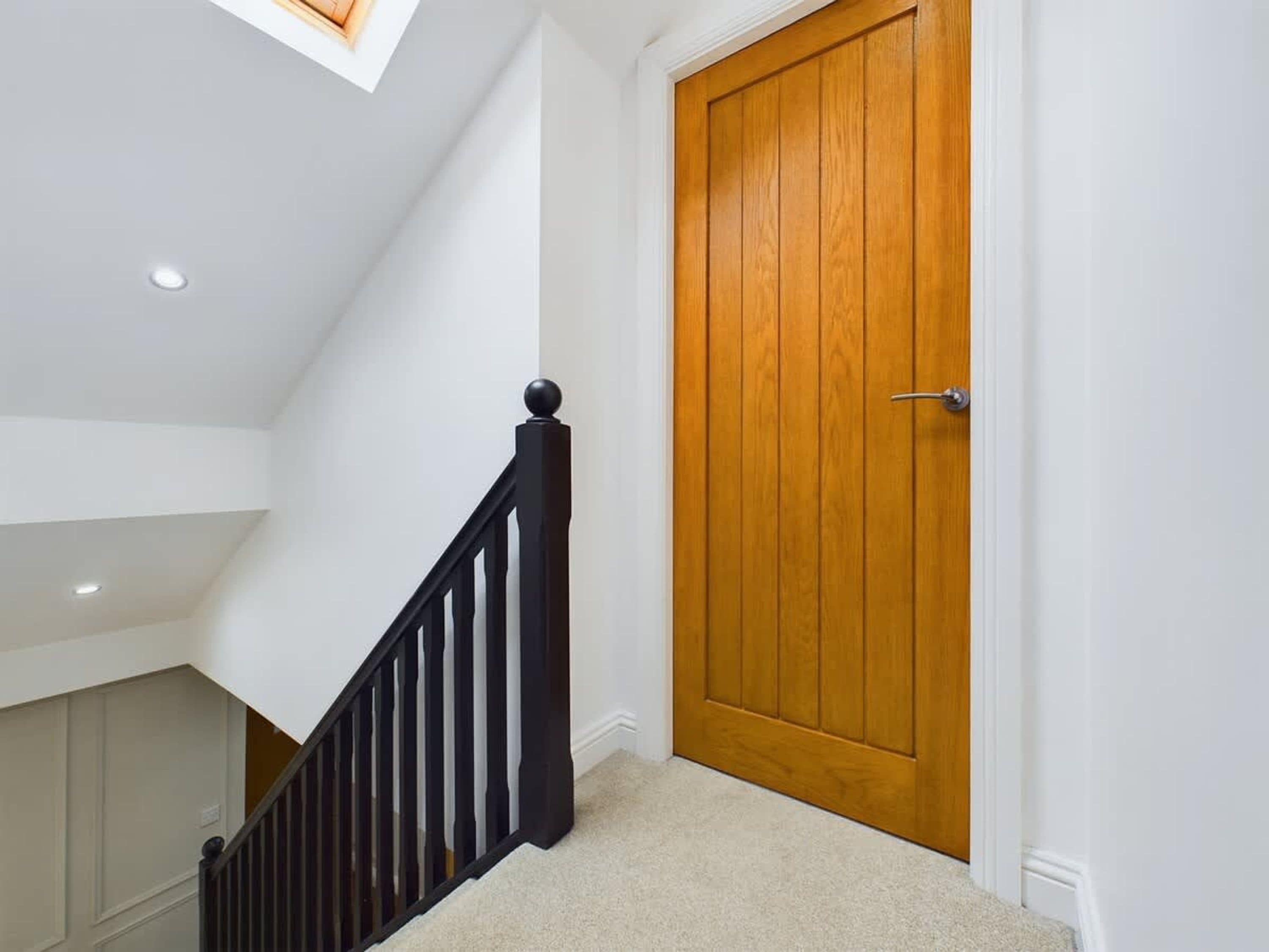 Un escalier avec une rampe en bois menant à une porte en bois.