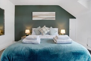 A bedroom with a bed, pillows, a nightstand, a lamp, and a painting on the wall. - 3 Bed in Sunderland With Free Wifi (Sunderland)