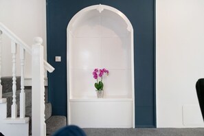 A room with a white staircase, a dark blue wall, and a white arched window with a potted orchid. - 3 Bed in Sunderland With Free Wifi (Sunderland)