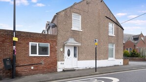 A two-story house with a white front door, a satellite dish, and a brick wall. - 3 Bed in Sunderland With Free Wifi (Sunderland)