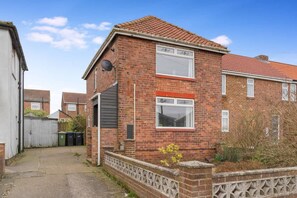 A two-story brick house with a tiled roof, a satellite dish, and a gated driveway. - Stylish Home Near Durham Heritage Coast Sleeps 5 (Durham)