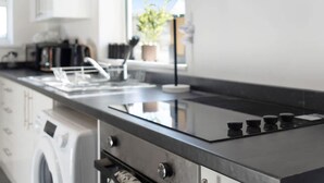 Een moderne keuken met een roestvrijstalen fornuis, een inbouwoven en een vaatwasser.