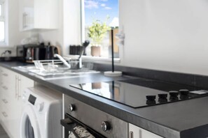 A modern kitchen with a stainless steel range, a built-in oven, and a dishwasher. - Stylish Home Near Durham Heritage Coast Sleeps 5 (Durham)