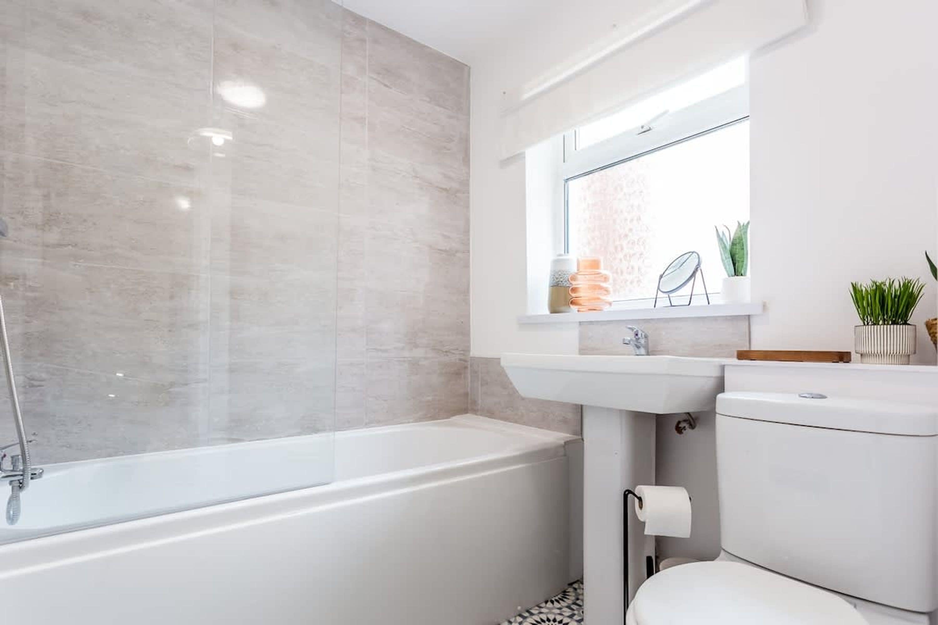 A modern bathroom with a bathtub, a sink, and a toilet.