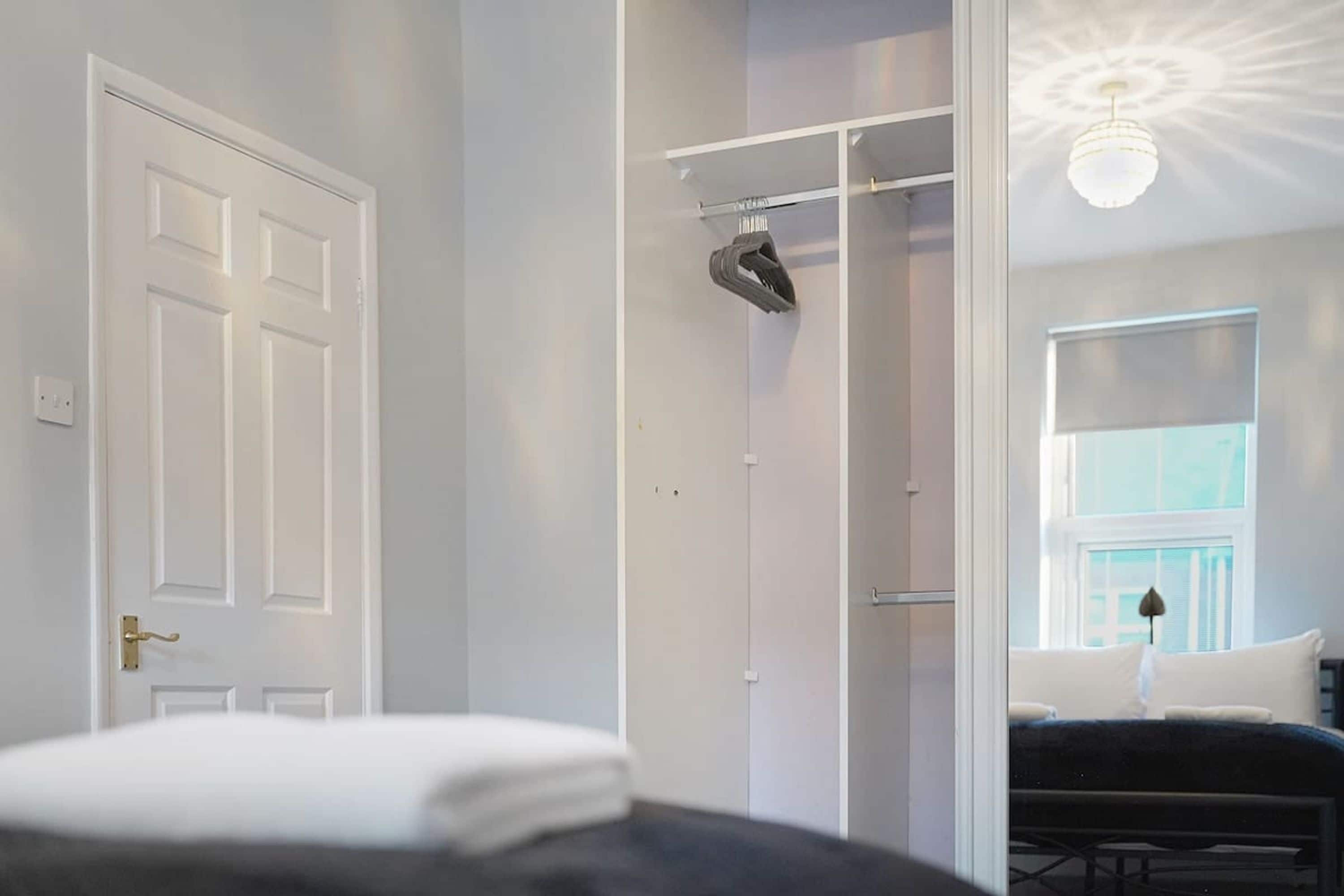 A bedroom with a bed, a wardrobe, and a window.