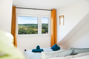 A bedroom with a bed, a window with curtains, and a view of a landscape. - Chic 3BR Rotherham Parking Wifi By Stay With us (Rotherham)