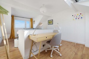 A modern bedroom with a sloped ceiling, a desk with a chair, a bed, and a window with curtains. - Chic 3BR Rotherham Parking Wifi By Stay With us (Rotherham)