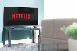 Un televisor sobre un soporte con la palabra 'NETFLIX' en la pantalla.