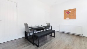 A dining area with a table set for two, a bench, and a radiator. - Charming 3BR in Blyth (Blyth)