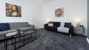 A modern living room with two sofas, a coffee table, and artwork on the walls. - Charming 3BR in Blyth (Blyth)