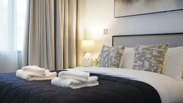 Une chambre d’hôtel avec un lit, une table de chevet, une lampe et une vue sur la mer.