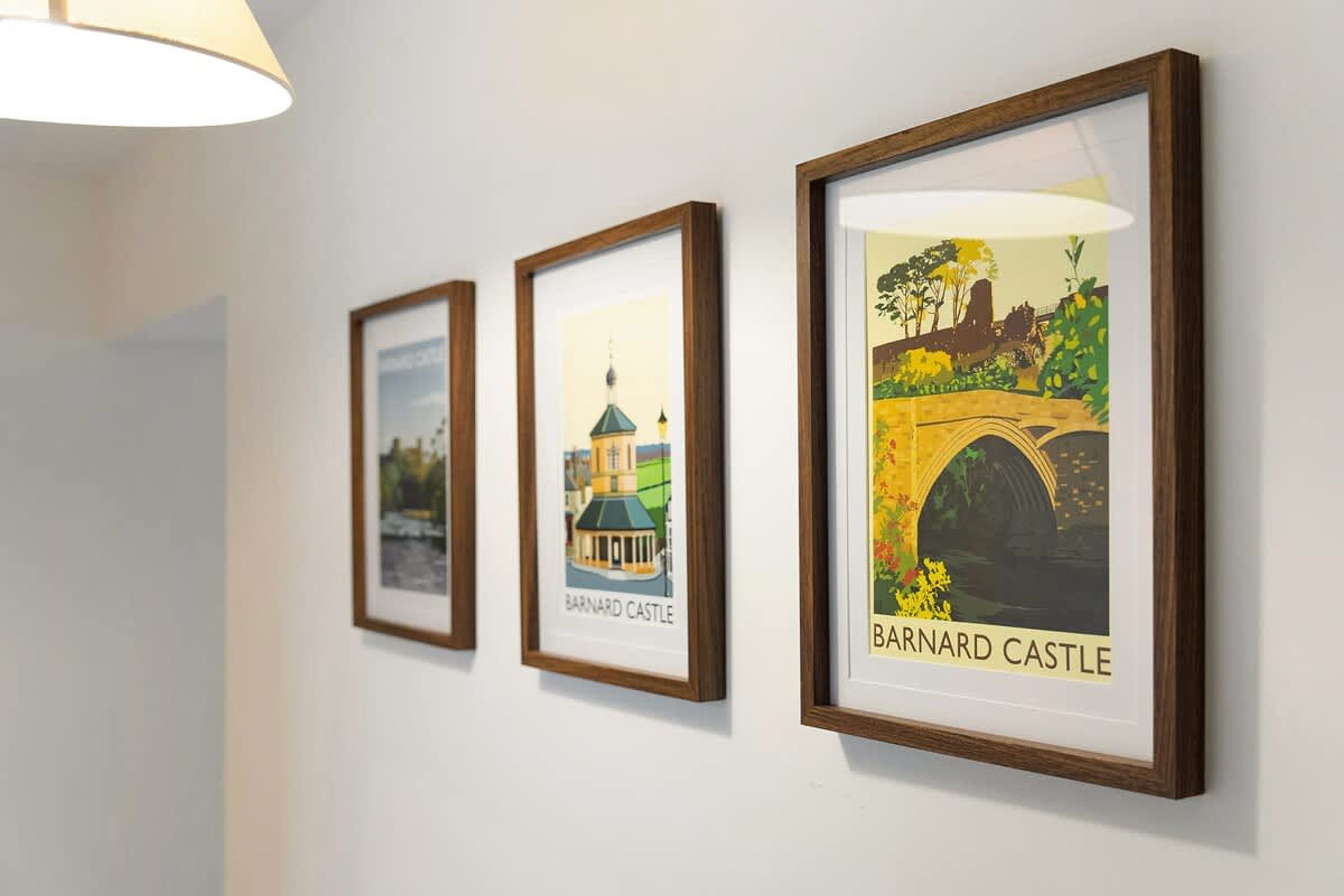Three framed pictures of Barnard Castle on a white wall.