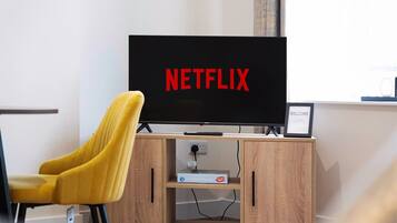 A television with the Netflix logo on a stand in a room.