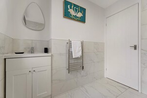 Un baño con tocador, perchero, espejo y puerta.