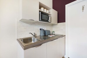 A kitchen with a built-in microwave, a sink, and a toaster.