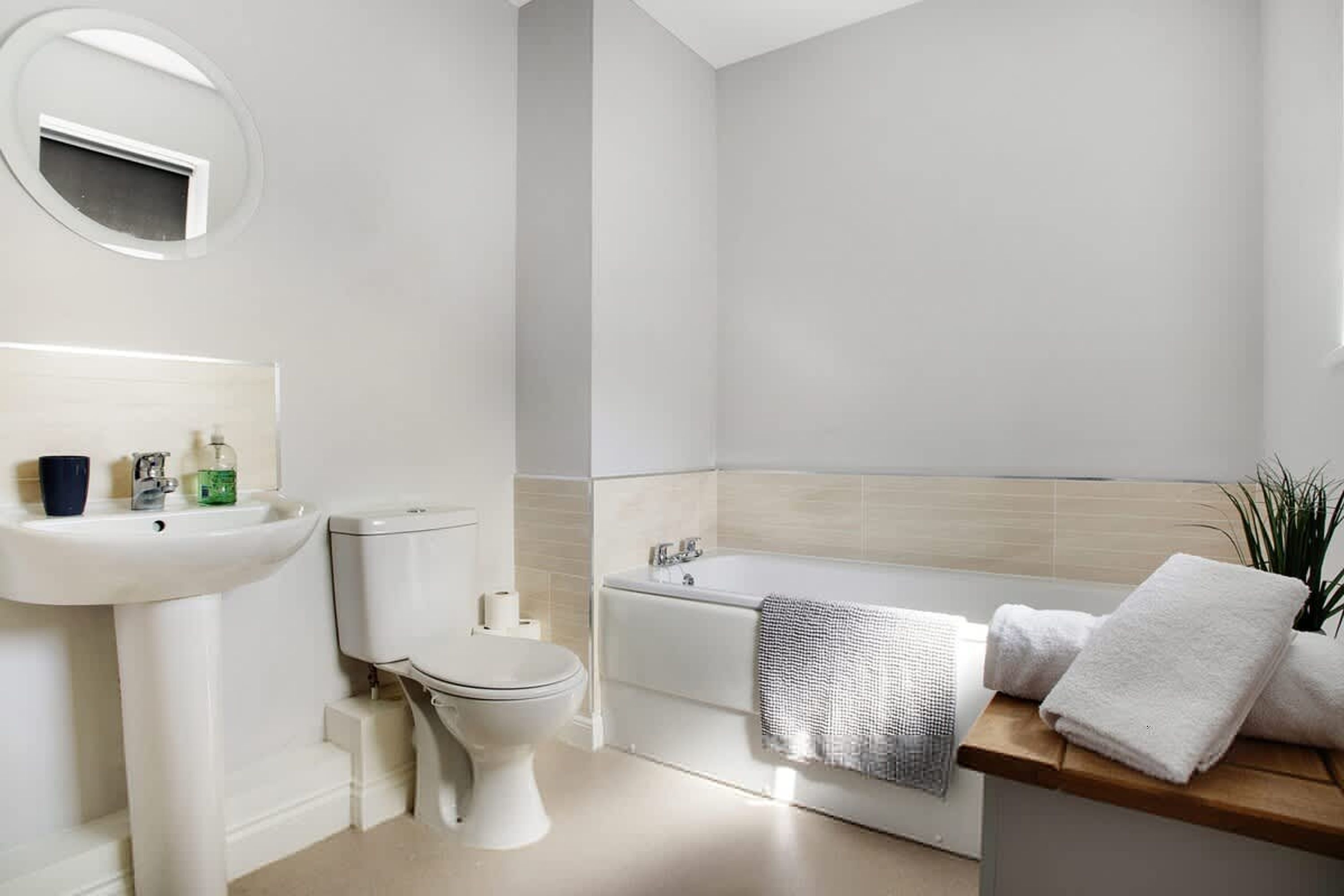 A modern bathroom with a toilet, sink, and bathtub.