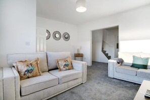 A living room with two sofas, a coffee table, and a staircase leading to another level. - Family two Bedroom Home Free Parking and Backyard (Crook)