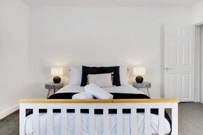 A bedroom with a bed, two bedside tables, and a door. - Family two Bedroom Home Free Parking and Backyard (Crook)